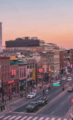 a city street filled with lots of traffic and people walking on the side of it