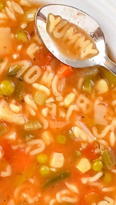 a spoon is full of soup with noodles and vegetables