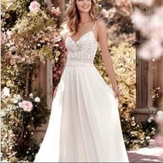 a woman in a white wedding dress posing for the camera