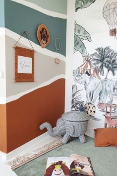 a child's room with an elephant and giraffe mural on the wall