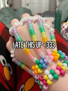 a person wearing colorful bracelets with the words i ate this up 333