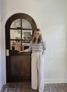 a woman standing in front of a wooden door