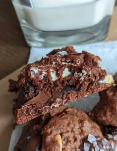 three chocolate cookies with white frosting and one half eaten