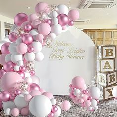 pink and white balloons are in the shape of a baby shower arch