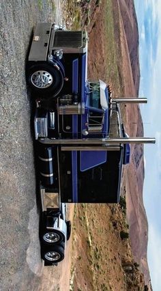 a semi truck parked on the side of a mountain