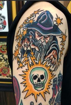 a man's arm with an old school style tattoo on it and a skull in the center