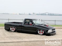 a black truck parked next to a body of water