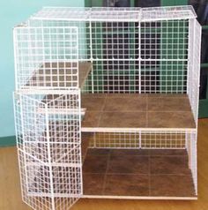 a white bird cage sitting on top of a wooden floor