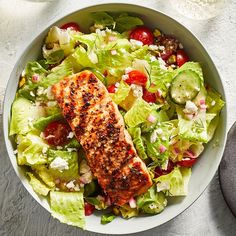 a salad with salmon and lettuce in a bowl