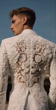 the back of a man's white jacket with flowers on it