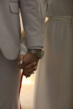 the bride and groom are holding hands