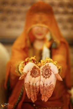 a woman with her hands painted in hendi and holding it up to the camera