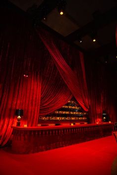 a stage with red curtains and lights on it