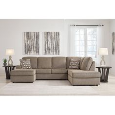 a living room scene with focus on the sectional sofa and pillows, along with two side tables