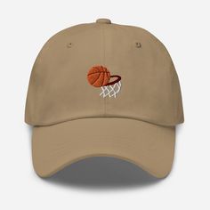 Elevate your sports style with the Basketball Embroidered Dad Hat, where athletic design meets comfort and versatility. 🏀 🧵 Product Details: Material: Crafted from 100% cotton twill, ensuring a soft and comfortable feel. * Design: Showcases a bold basketball embroidered motif, expressing your love for the game and athletic spirit. * Style: Features an unstructured, 6-panel, low-profile design, offering a laid-back and sporty aesthetic. * Ventilation: Designed with 6 embroidered eyelets to prov Sports Cotton Trucker Hat With Letter Print, Cotton Trucker Hat For Baseball Sports, Cotton Trucker Hat For Baseball Season Sports, Casual Baseball Cap With Cotton Sweatband For Sports, Cotton Trucker Hat For Baseball Season, Breathable Cotton Trucker Hat For Sports, Breathable Cotton Snapback Baseball Cap, Breathable Cotton Hats For Sports Events, Breathable Cotton Baseball Cap With Curved Bill