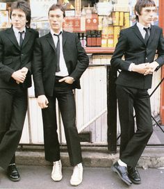 three young men in suits standing next to each other