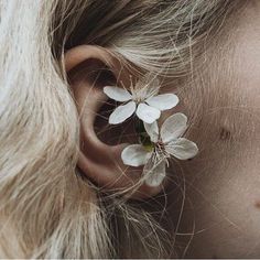 a close up of a person's ear with flowers in the middle of it