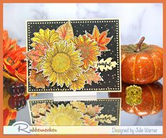 an orange and black card with sunflowers on it next to some pumpkins