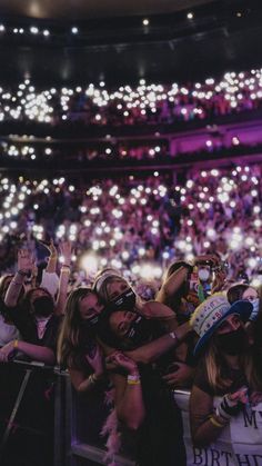 a group of people standing next to each other in front of a crowd at a concert