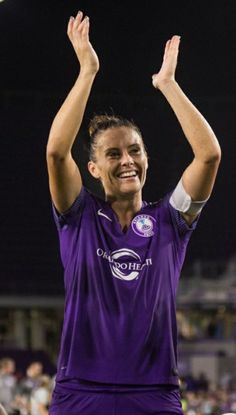 a soccer player is holding his hands up in the air and smiling at the camera