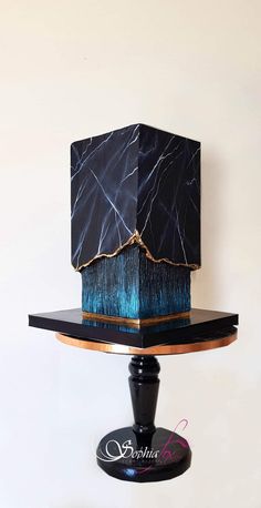 a black and blue lamp on a wooden stand