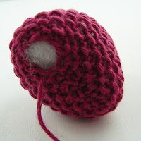 a ball of yarn sitting on top of a white table next to a red thread