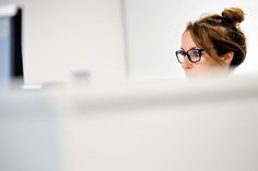 a woman wearing glasses looking at her computer screen