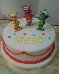 a birthday cake with three small figurines on top