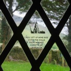 a close up of a window with a sign on it that says i will lift up mine eyes unto the hills