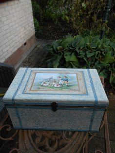 a blue box sitting on top of a metal stand in front of a brick building