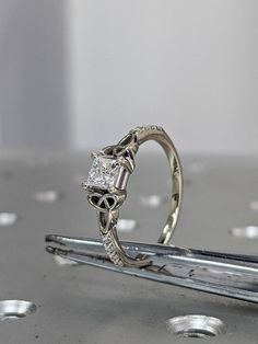 a diamond ring sitting on top of a piece of metal