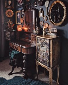 an antique desk with many pictures on the wall and candles in front of it next to a mirror