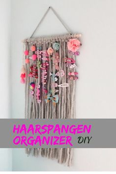 a wall hanging made out of yarn and beads with the words haarspangen organizer diy