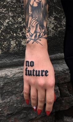 a woman's hand with the word no future tattooed on it, and an angel holding