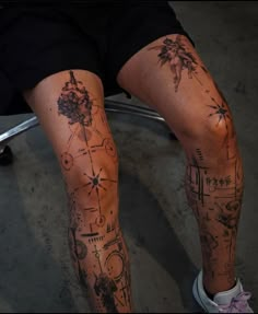 a person sitting down with tattoos on their legs