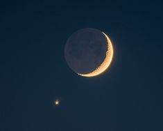 the moon and its half - moon are visible in the night sky