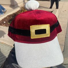 a person wearing a red and white hat with a gold square on it's peak