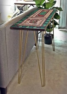 a table that is sitting in the middle of a room next to a couch and potted plant