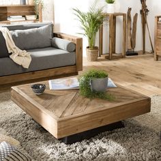 a living room filled with furniture and a wooden table in front of a gray couch