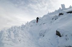 a man riding skis down the side of a snow covered slope on top of a mountain