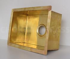 a gold metal object on a white surface