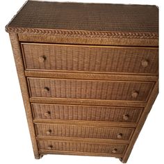 a brown wicker dresser with five drawers