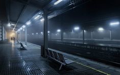 a bench sitting on the side of a train track in a foggy subway station