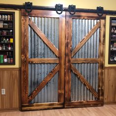 two wooden doors with metal bars on each side and shelves in the back behind them