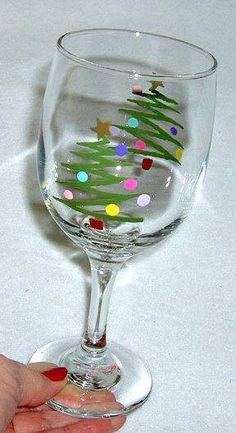 a wine glass with a christmas tree painted on it