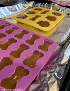 two pans filled with peanut butter and dog paw shaped muffins on top of tin foil