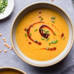 two bowls filled with soup on top of a table