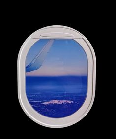 an airplane window with the view of mountains