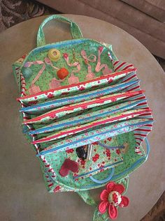 a green purse sitting on top of a table next to a flowery vase and pot holder