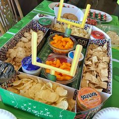 an assortment of snacks on a table at a football themed party with paper plates and napkins